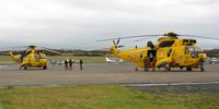 Swansea Airport, Swansea, Wales United Kingdom (EGFH) - Two RAF SAR helicopters on the apron after a rescue mission. From 202 and 22 Squadrons RAF. - by Roger Winser