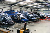 Shobdon Aerodrome Airport, Leominster, England United Kingdom (EGBS) - lineup of Bell 206 Jetrangers in the Tiger Helicopter's hangar at Shobdon. From L to R, G-OMDR, G-BYBI, G-XBOX, G-ONTV, G-SPEY, G-DOFY, G-BSBW.  - by Chris Hall