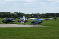 Denham Aerodrome Airport, Gerrards Cross, England United Kingdom (EGLD) - Robinson R44 and R22's outside the Heliair hangar - by Chris Hall