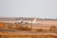 Sebha Airport - Remote stand with stored L1011 of Kallat El-Saker Air Company (one of three), a Il76 of LAA and a MIG29. View from hotel. - by FerryPNL
