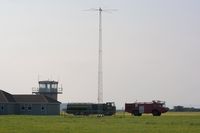 Pembrey Airport, Pembrey, Wales United Kingdom (EGFP) - Control Tower, fuel tender, radio mast and the airport Fire and Rescue tender #2. In the distance (between the two vehicles) can be see an observation tower on the adjacent DIO Pembrey Sands Air Weapons Range (EGOP).  - by Roger Winser