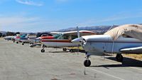 South County Arpt Of Santa Clara County Airport (E16) - Long line of locally-based single engine pistons at South County Airport, San Martin, CA. Most of these aircraft are non airworthiness. - by Chris Leipelt