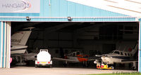 Blackpool International Airport, Blackpool, England United Kingdom (EGNH) - A sneaky look inside Hangar 3 at Blackpool EGNH. Picture taken from the rear of the Morrisons Supermarket. - by Clive Pattle