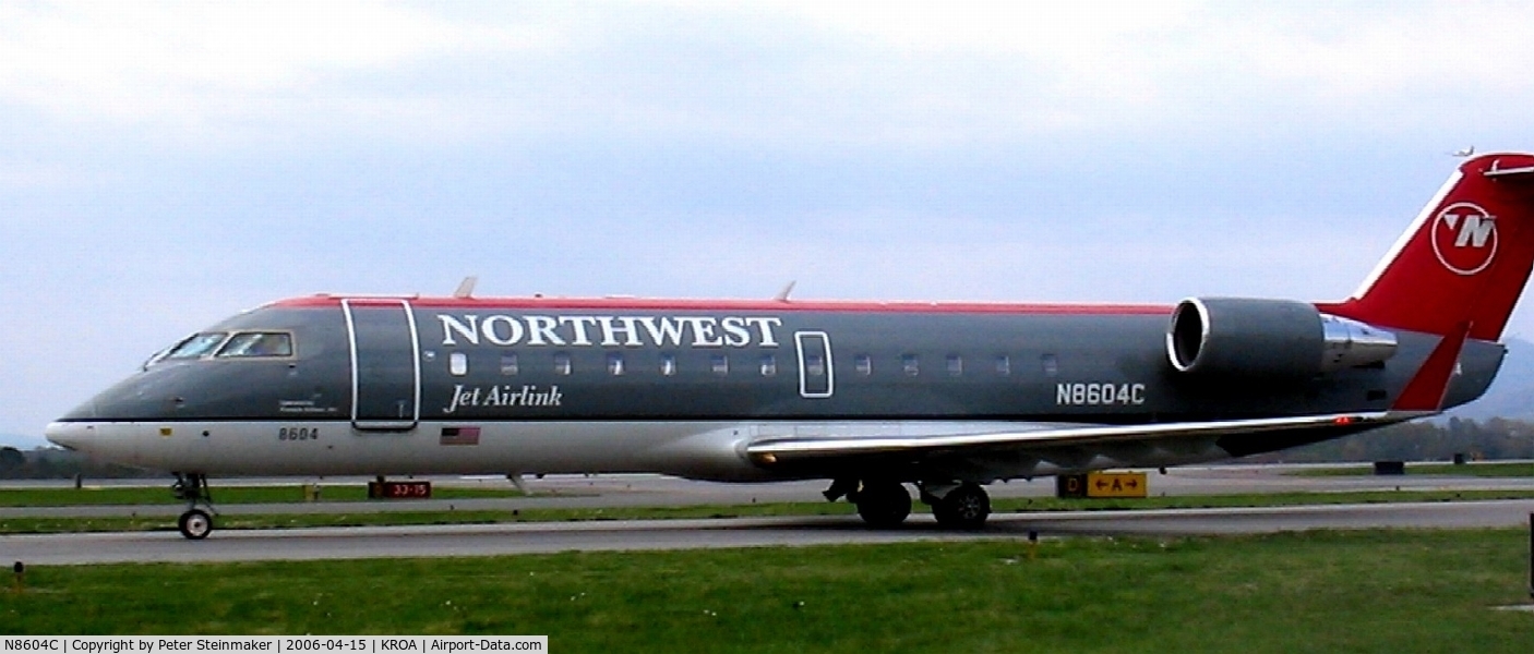 N8604C, 2002 Bombardier CRJ-200 (CL-600-2B19) C/N 7604, Taxiing to the terminal with a departure (just over the tail) in the background