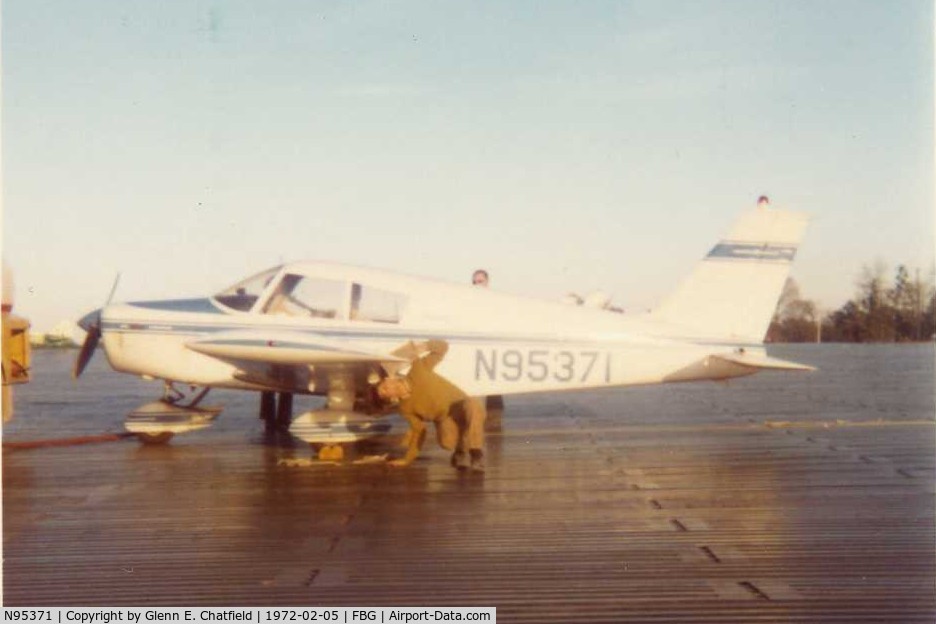N95371, 1969 Piper PA-28-140 C/N PA28-25903, No longer registered.  That's me preflighting one of my early flights, with a 6-month old license, taking friends flying.  Notice the ramp; our battalion built that from M8A1.