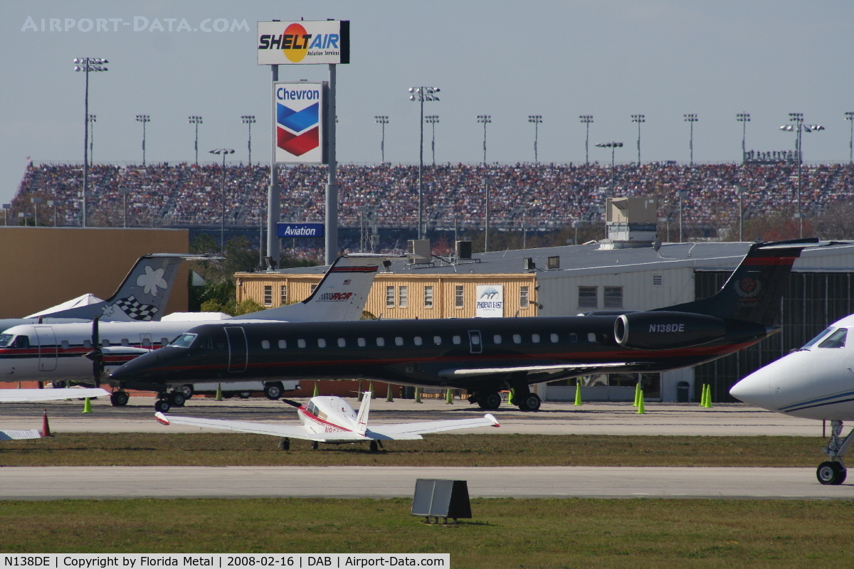 N138DE, 1999 Embraer EMB-145LU (ERJ-145LU) C/N 145129, Dale Earnhart Inc's new E145 parked with Daytona Speedway in background