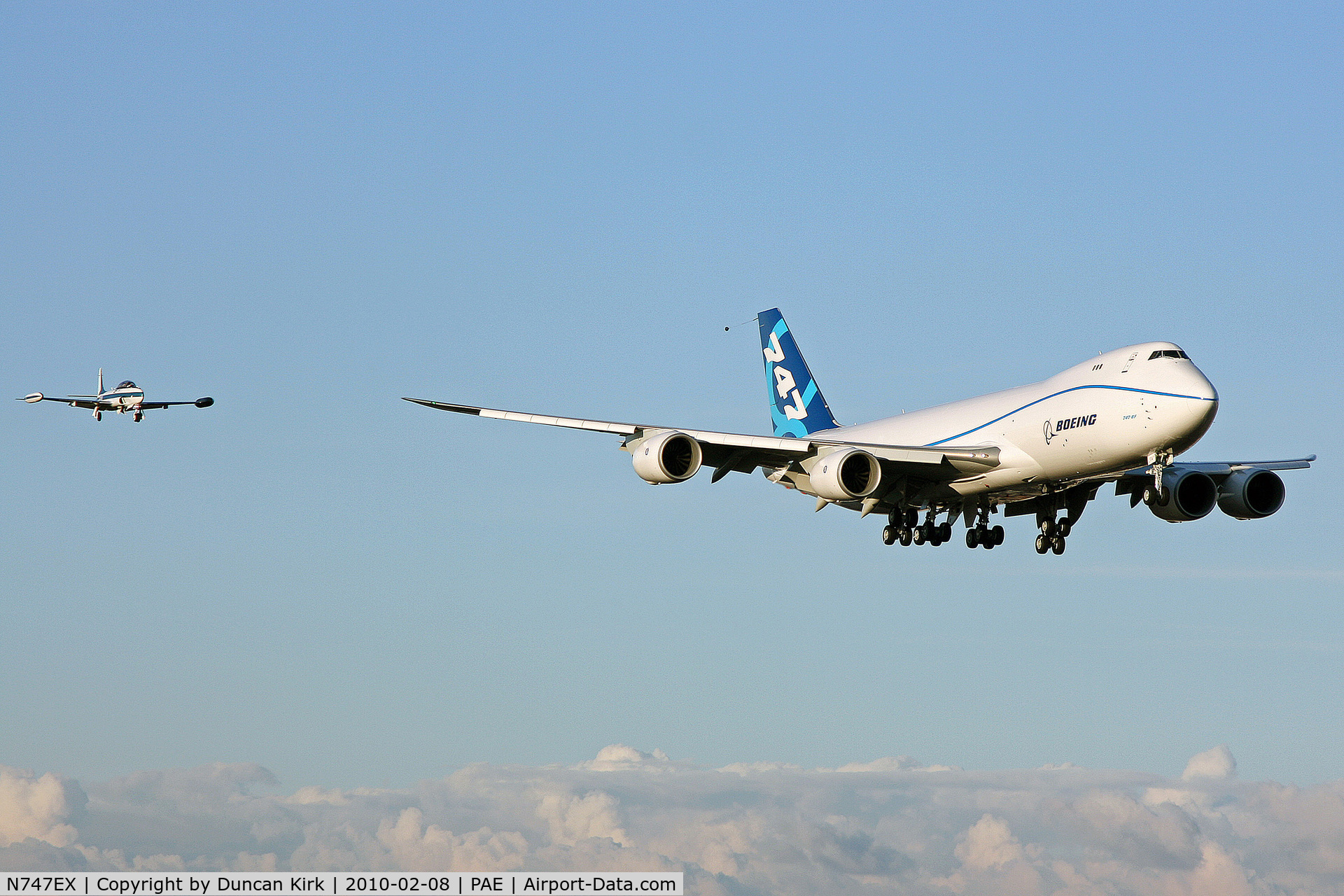 N747EX, 2010 Boeing 747-8F C/N 35808, First flight on finals with chase plane T-33