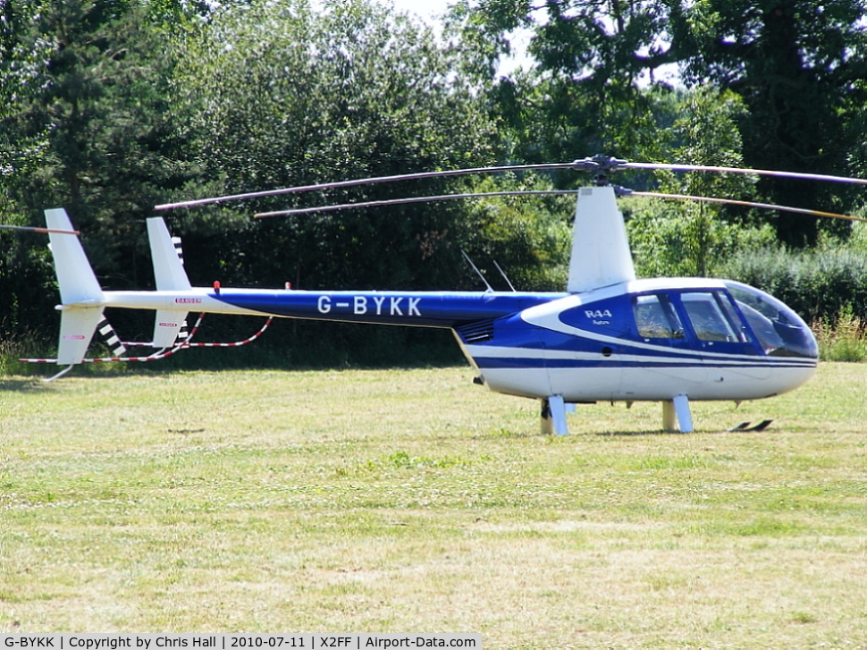 G-BYKK, 1999 Robinson R44 Astro C/N 0572, Robinson R44 being used for ferrying race fans to Silverstone for the British Grand Prix from this temporary heliport a few miles east of Bicester