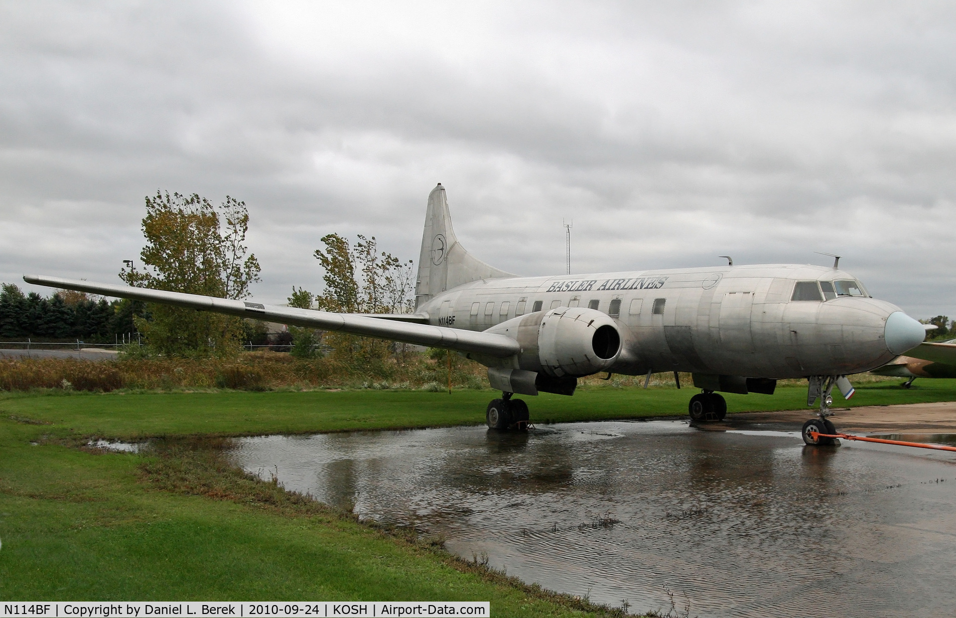 N114BF, 1955 Convair 340 C/N 146, Bereft of its engines, this rare Convairliner sits in a puddle at the Balser compound at Oshkosh.