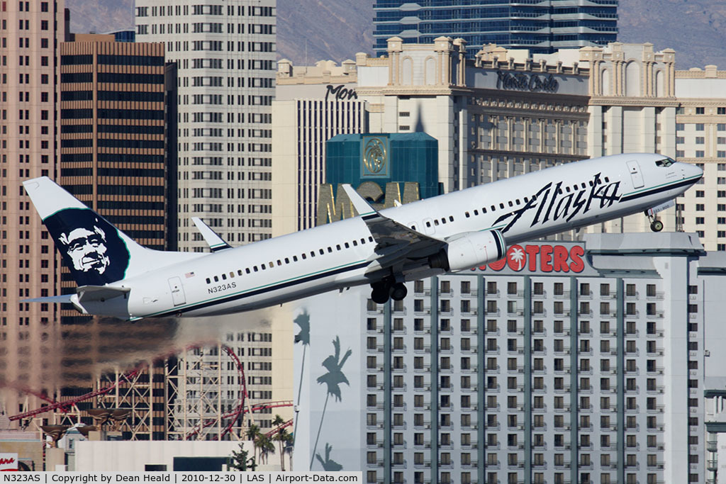 N323AS, 2004 Boeing 737-990 C/N 30021, Alaska Airlines N323AS (FLT ASA619) climbing out from RWY 1R en route Seattle-Tacoma Int'l (KSEA), with the Monte Carlo Hotel and the Hooters Hotel in the background.