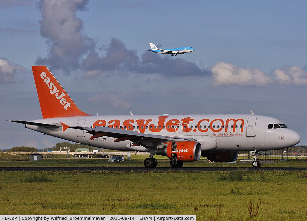 HB-JZP, 2005 Airbus A319-111 C/N 2427, Roll out on 18R,
in the back KLM Boeing 747-406 on final approach
to runway 18C.