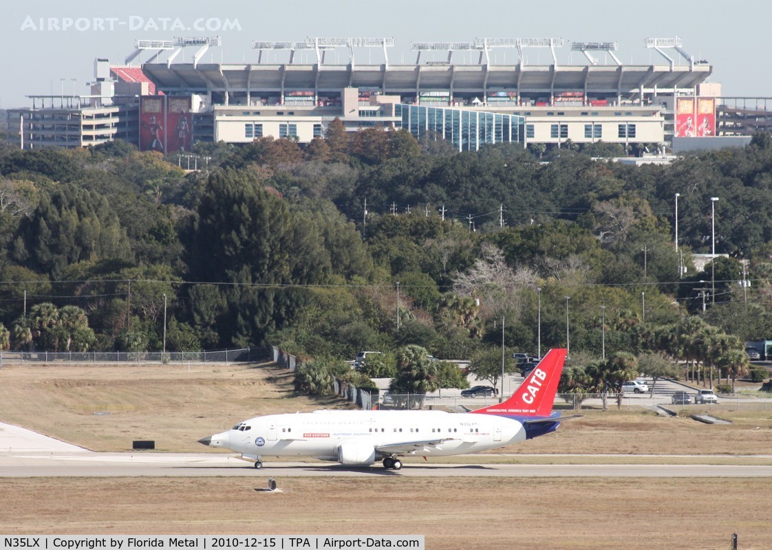 N35LX, 1986 Boeing 737-330 C/N 23528, Catbird taxiing out for a test flight after work being done on it - Raymond James Stadium, home of the Tampa Bay Bucaneers in background