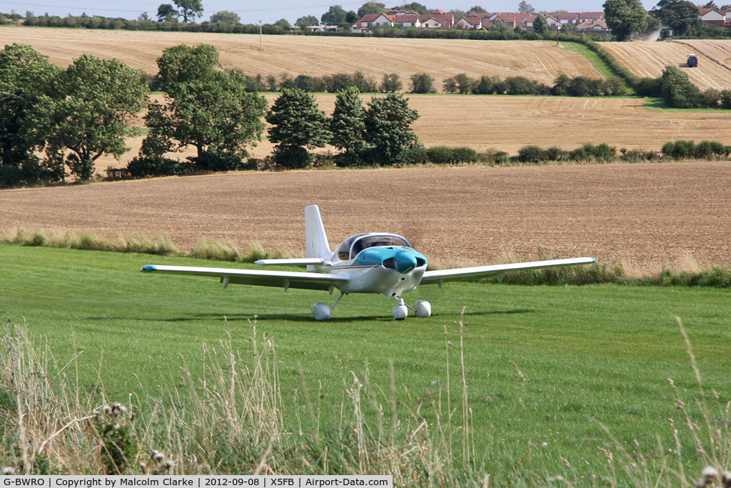 G-BWRO, 1997 Europa Tri-Gear C/N PFA 247-12849, Harvest in progress in the surrounding fields as a Europa takes off from 26 at Fishburn Airfield UK , September 2012.