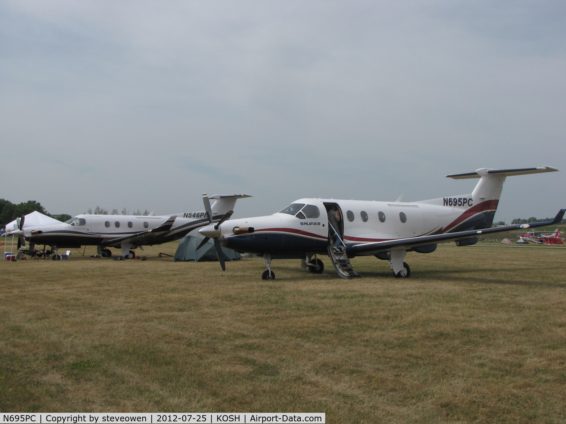 N695PC, 1999 Pilatus PC-12/45 C/N 305, In the camp grounds at EAA2012.N546PB in the back.