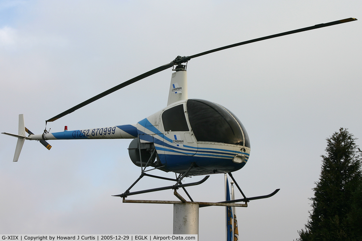 G-XIIX, 1988 Robinson R22 Beta C/N 0736, Up a pole by the airfield entrance.