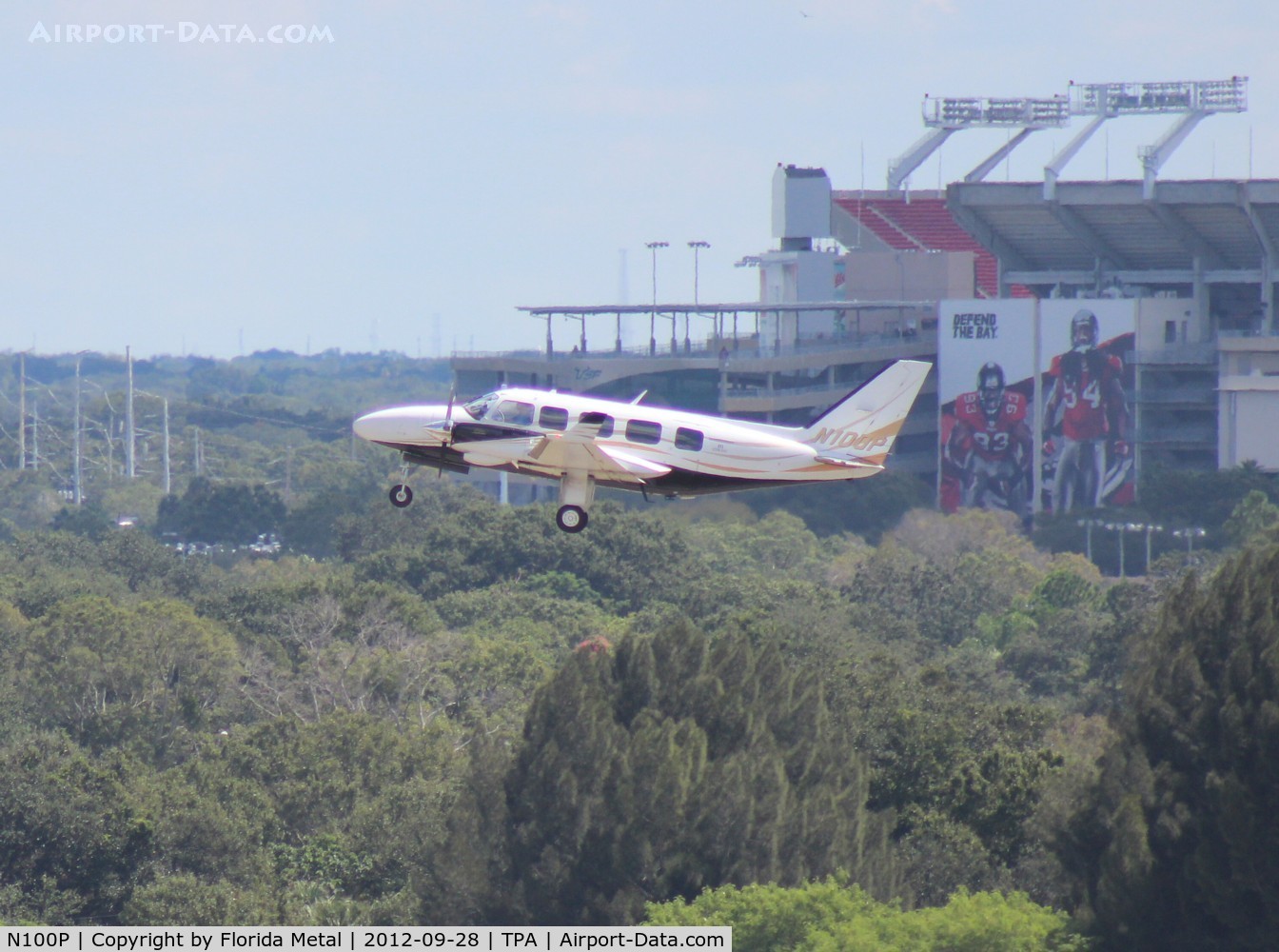 N100P, 1982 Piper PA-31-350 Chieftain C/N 31-8252019, PA-31-350 taking off at Tampa with Raymond James (Tampa Bay Buccaneers NFL team) Stadium in background
