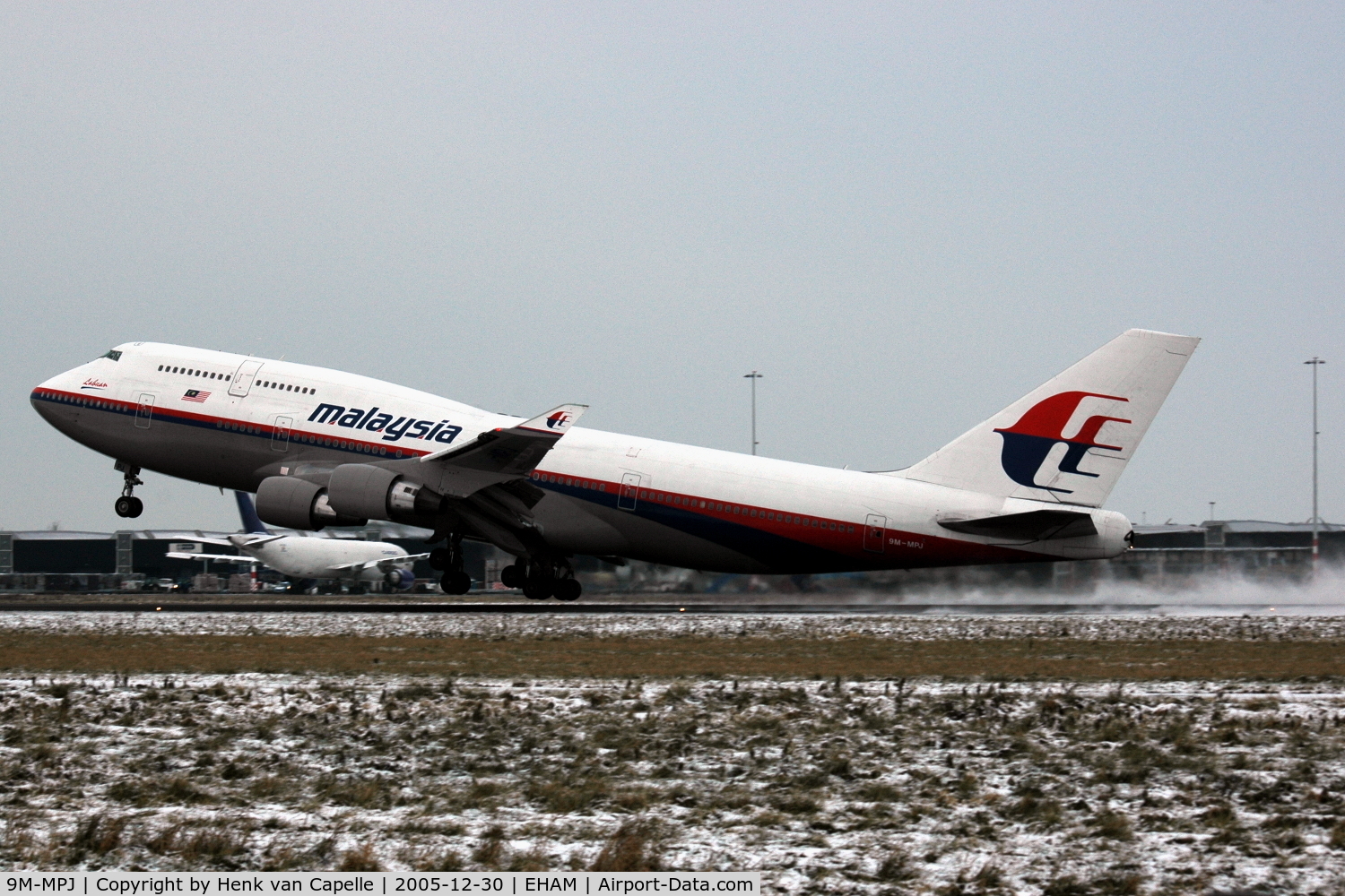 9M-MPJ, 1997 Boeing 747-4H6 C/N 28426, Malaysia Airlines Boeing 747-400 kicking up snow while taking off from Amsterdam Schiphol airport, the Metherlands.