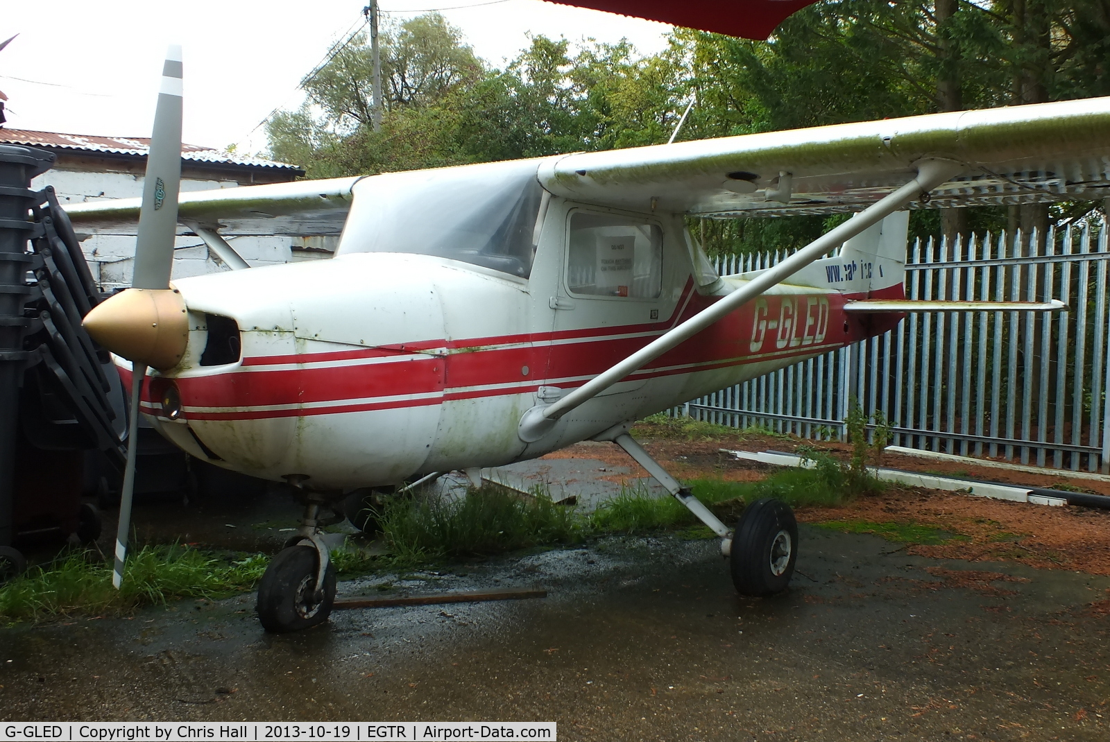 G-GLED, 1975 Cessna 150M C/N 150-76673, parked in the gap between two hangars