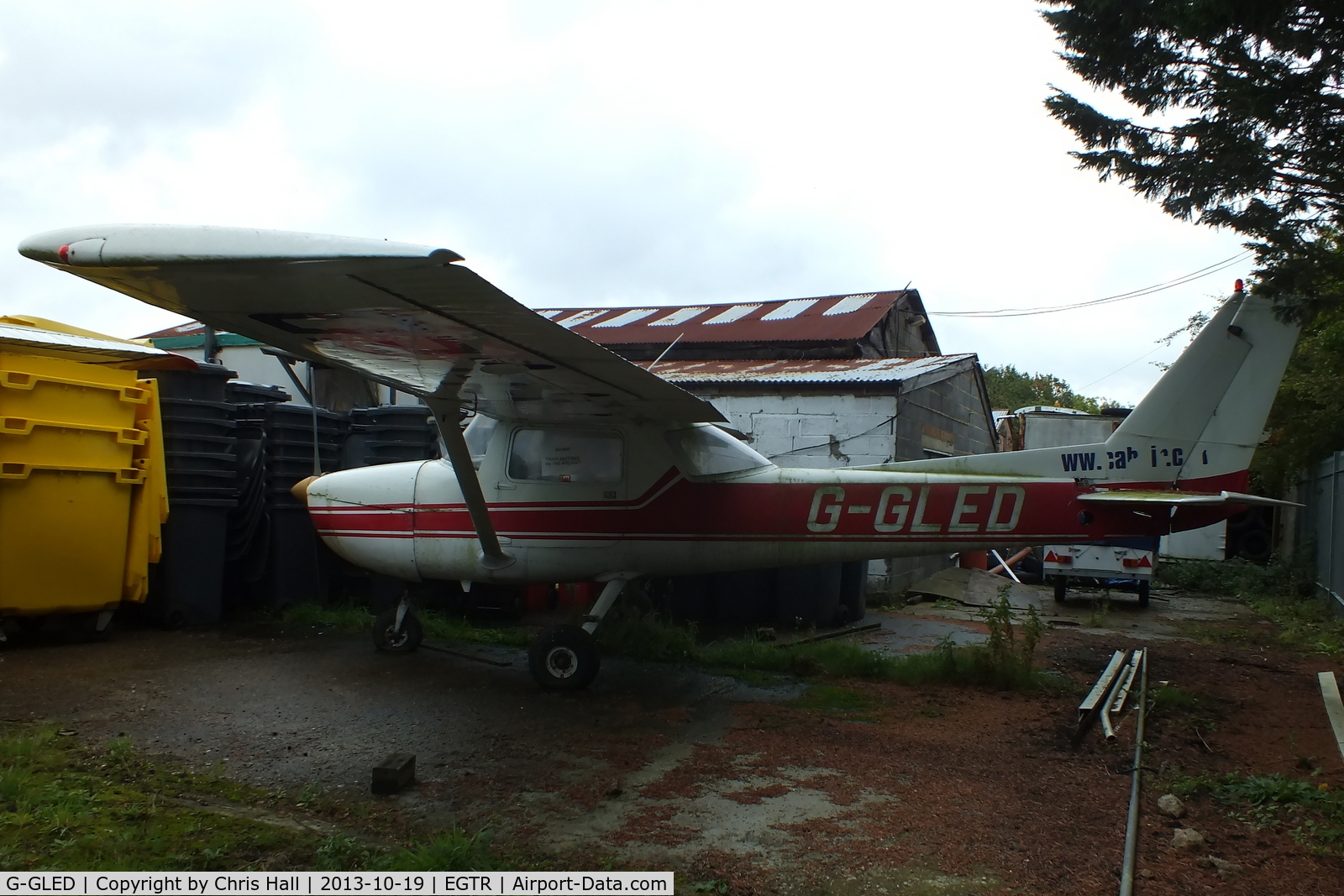 G-GLED, 1975 Cessna 150M C/N 150-76673, parked in the gap between two hangars
