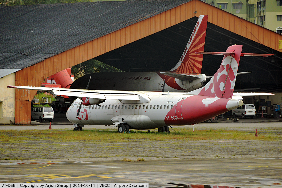 VT-DEB, 1995 ATR 72-202(F) C/N 456, A wet, grey afternoon at Calcutta reveals all sorts of stored equipment in the distance. Behind the ATR-72 is an Air India Cargo B-737, Indian Airlines ground equipment and a Kingfisher bus.
