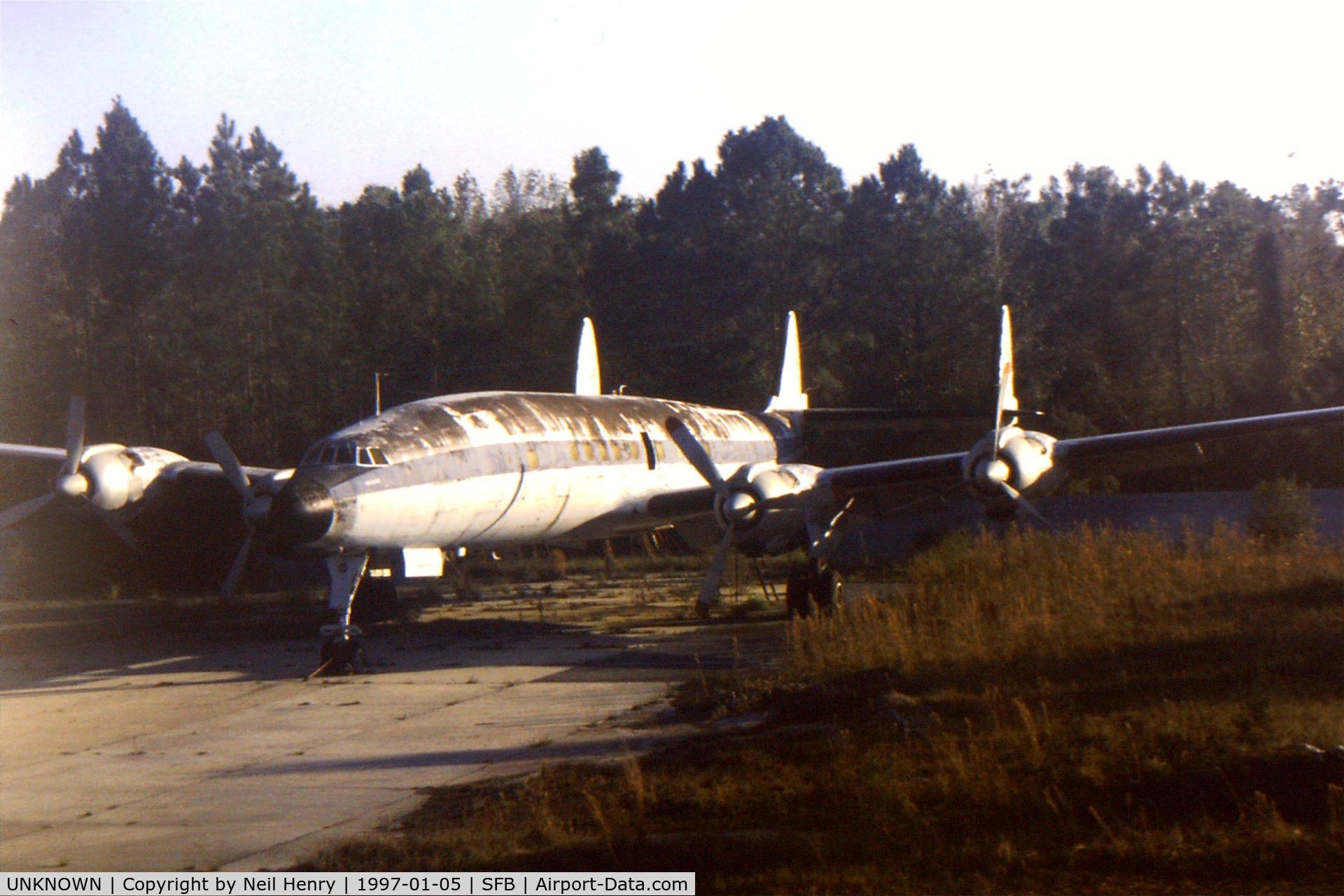 UNKNOWN, Miscellaneous Various C/N unknown, Derelict Lockheed Constellation (unidentified) possibly used for training ground staff - parked at northern end on main runway SFB - as seen from departing flight.  Scanned from original slide