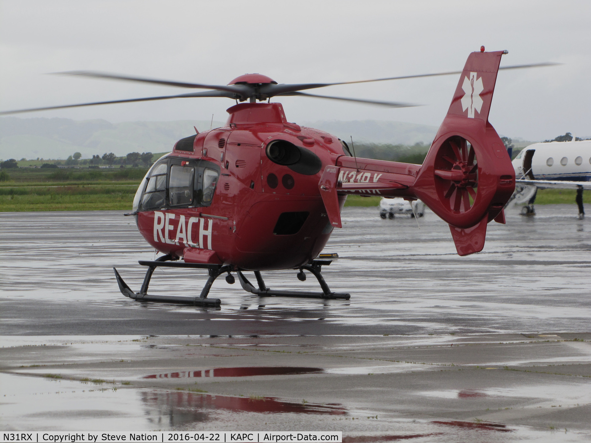 N31RX, 2012 Eurocopter EC-135P2+ C/N 1087, REACH/Mediplane (Santa Rosa, CA) 2012 Eurocopter EC-135P2+ waiting for ambulance to pickup and transport patient on rainy ramp @ Napa County Airport, CA