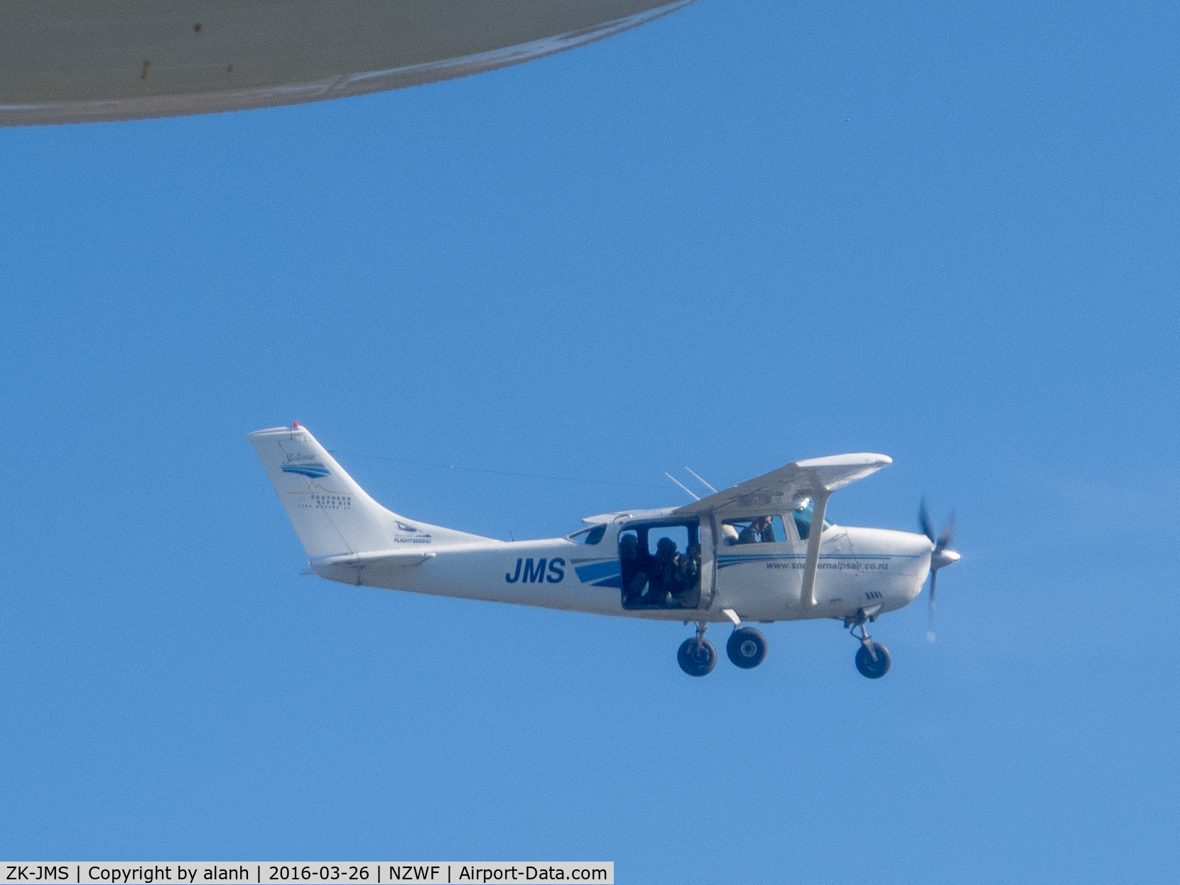 ZK-JMS, Cessna U206F Stationair C/N U20601838, Taken from ZK-PBY out of Wanaka, after the Saturday airshow. There are 3 photographers in the back of JMS shooting the Catalina. Wingtip float of PBY visible top left.