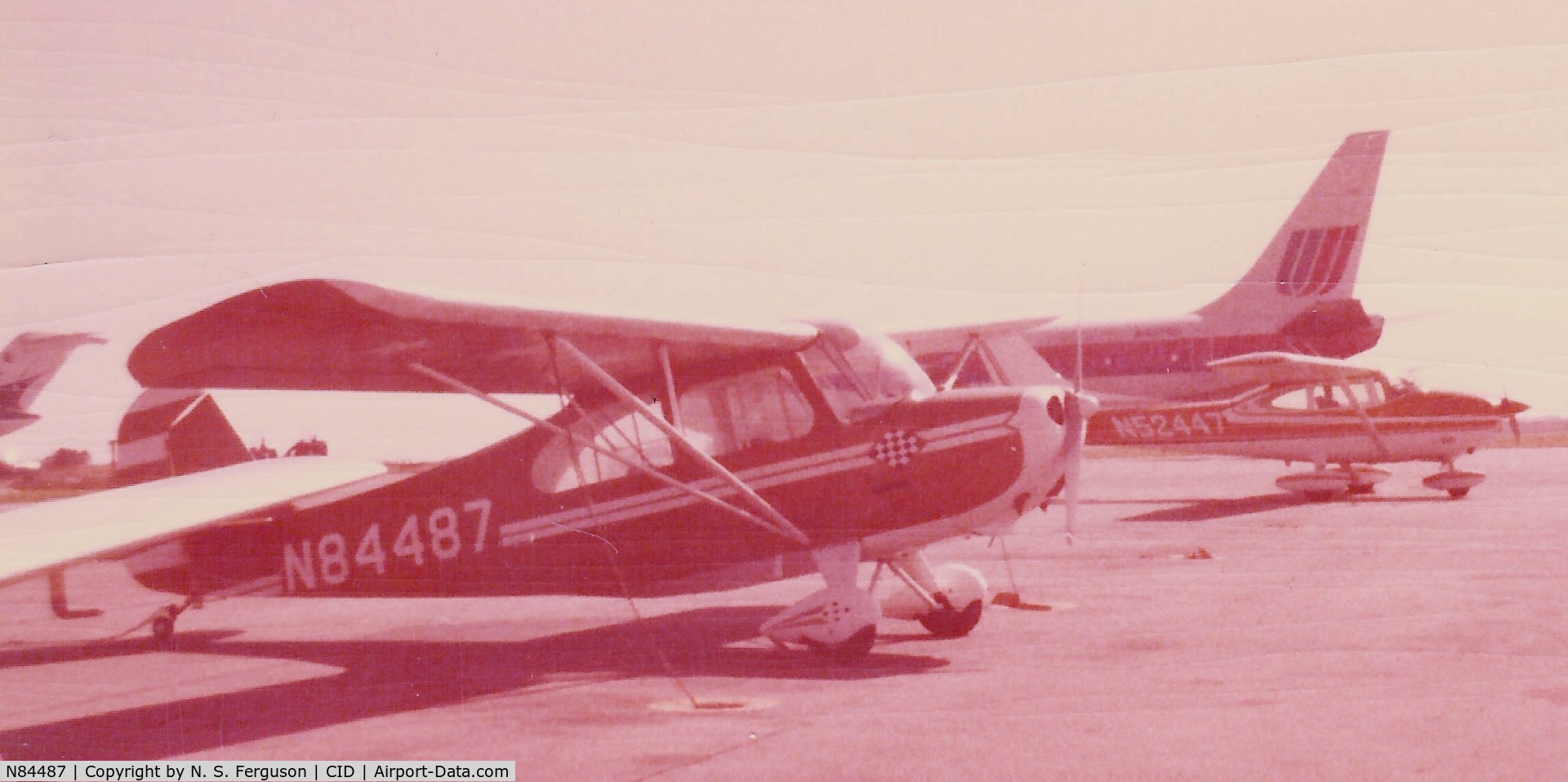 N84487, 1946 Aeronca 7AC Champion C/N 7AC-3185, Circa 1980.  Photo faded, unfortunately, before it was scanned.  Primary color was a yellowish tan.  Tied down at the Cedar Rapids, IA (CID) airport just prior to a static display airshow.
