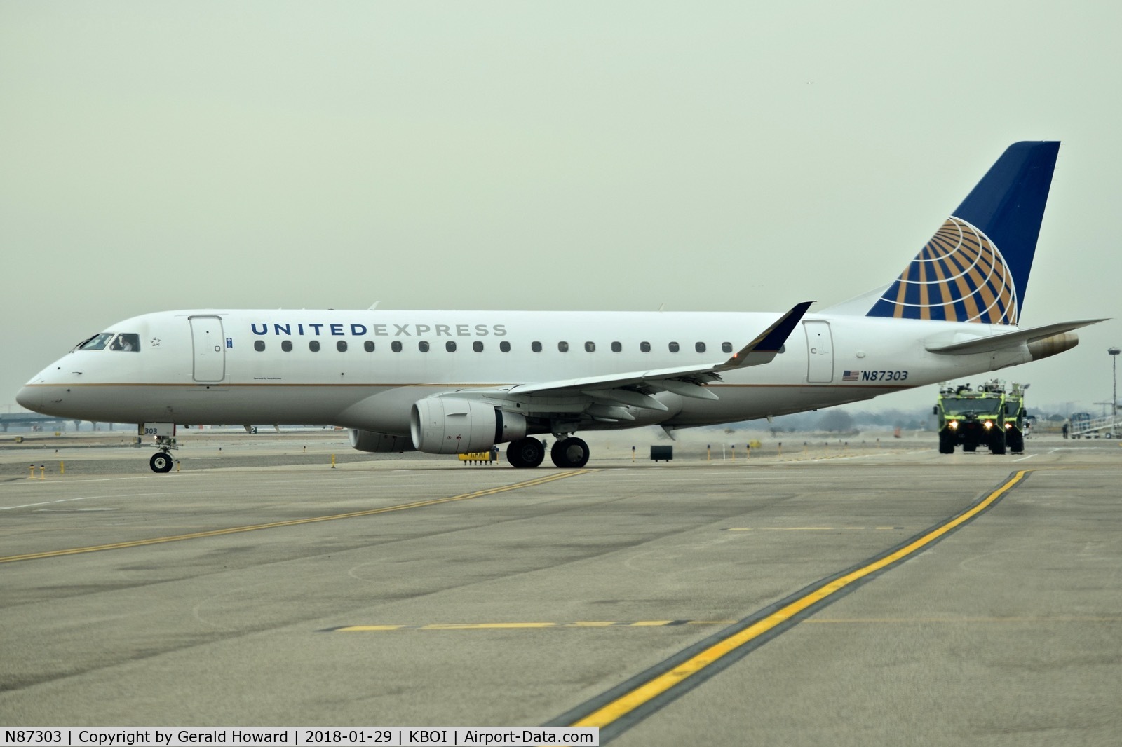 N87303, 2014 Embraer 175LR (ERJ-170-200LR) C/N 17000398, Taxiing from the ramp to Taxiway Alpha. ARFF units in the back ground are returning from a drill.