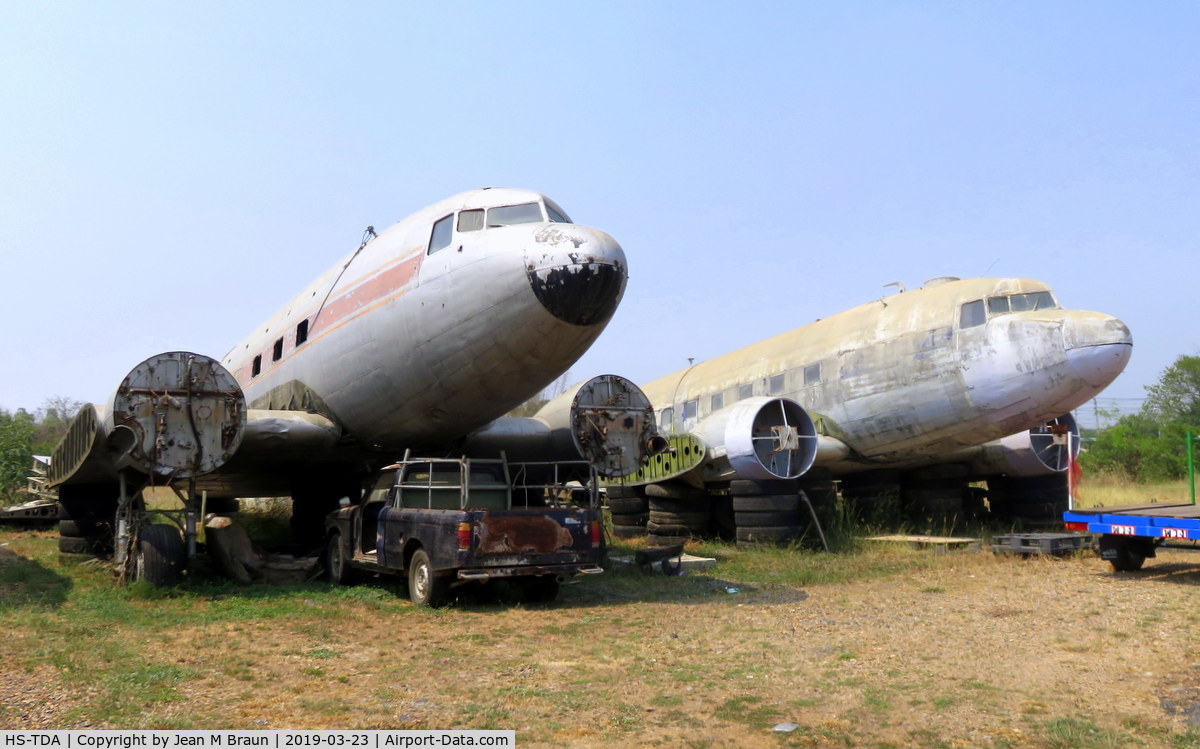 HS-TDA, 1943 Douglas DC-3 C/N 13726, ex 42-93777 / cn 13726 ex HS-TDA Thai Airways dismantled in a lumber yard on countryroad #3056 in Phachi. province of Ayutthaya / Thailand. Next to her ex 44-76842 ex RAF KN559