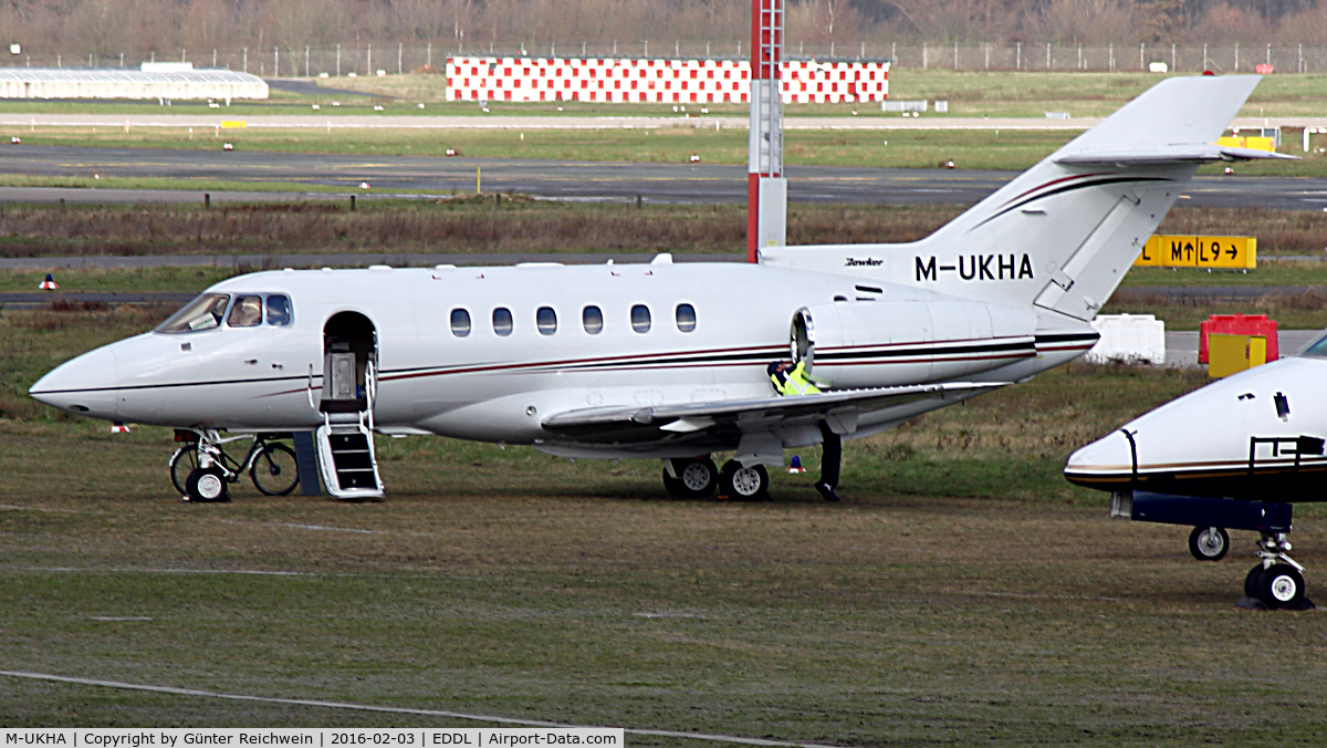 M-UKHA, 2003 Raytheon Hawker 800XP C/N 258625, Note the athletic mechanic and his bike leaned to the front gear