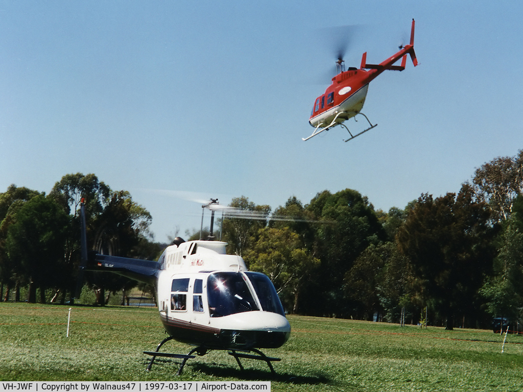 VH-JWF, 1981 Bell 206B-3 JetRanger III C/N 3421, Front Stbd view of Bell 206 VH-JWF Cn 3421 on the grass near Lake Burley Griffin Canberra during Canberra Week festivities on 17Mar1997 (Canberra Day). Bell 206L-3 LongRanger III VH-SBC is departing at rear.