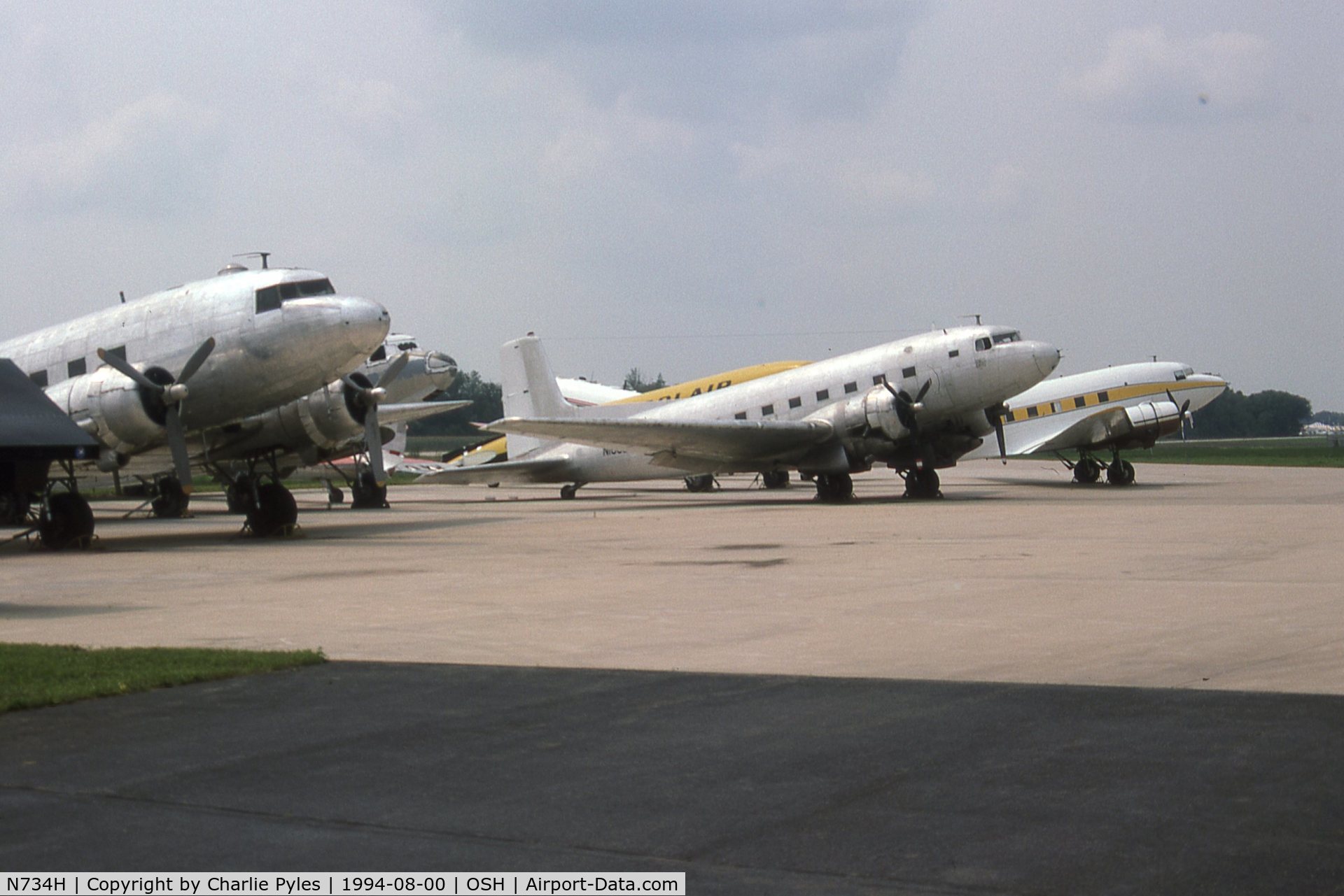 N734H, 1942 Douglas DC-3 (C-47-DL) C/N 4727, N734H is the yellow airplane in the background on this Basler Ramp in 1994. The yellow/black airplane behind it is N23SA,  the Polair Conroy Tri-Turbo-Three was a Douglas DC-3 fitted with three Pratt & Whitney Canada PT6A turbop