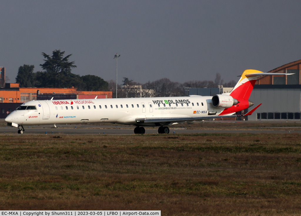 EC-MXA, 2018 Bombardier CRJ-1000 (CL-600-2E25) C/N 19064, Taxiing holding point rwy 32L for departure... Additional 'HOY BOLAMOS con BIOCOMBUSTIBLES avansados Cepsa' titles