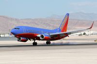 N242WN @ LAS - Southwest Airlines N242WN touching down on the right main gear first on RWY 25L. - by Dean Heald