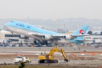 HL7472 @ LAX - Korean Air HL7472 (FLT KAL18) departing RWY 25R enroute to Incheon Int'l (RKSI) as work crews continue work on RWY 25L in the foreground. - by Dean Heald