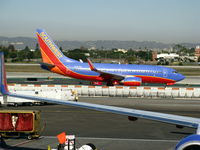 N442WN @ LAX - Southwest 2003 Boeing 737-7H4 in new colors w/winglets framed by gate-mate - by Steve Nation