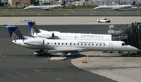 N16541 @ KEWR - Accompanied by a sibling, an Express Jet awaits her next load of passengers at Newark. - by Daniel L. Berek