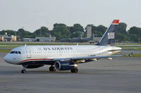N825AW @ KMSP - A former America West A319, now in US Airways colors, pulls up at MSP; the Herks in the background belong to the Minnesota ANG. - by Daniel L. Berek