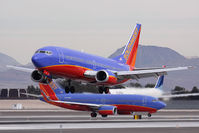 N350SW @ LAS - Southwest Airlines N350SW landing RWY 25L, while Southwest Airlines N243WN holds short, and Delta Air Lines N840MH holds in position on RWY 25R. - by Dean Heald