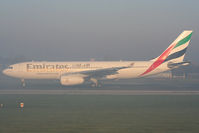 A6-EKT @ EGCC - Emirates A330 lining up on 23R in the early morning fog - by Chris Hall