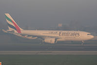 A6-EKT @ EGCC - Emirates A330 taxiing to 23R in the early morning fog - by Chris Hall