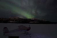 C-GINC @ CEZ5 - On skis on Lake Schwatka, with the aurora borealis (Northern Lights) overhead. - by Murray Lundberg