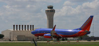 N555LV @ KAUS - The afternoon sun beats down as a SWA B737 lands with the Tower in the background. - by Darryl Roach