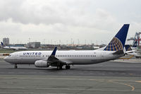 N24212 @ KEWR - A United Boeing 737-800 taxies out at a very soggy Newark Airport. - by Daniel L. Berek