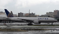 N27015 @ KEWR - An ex-Continental Triple-7 taxies by on a very wet Newark ramp just after a downpour. - by Daniel L. Berek