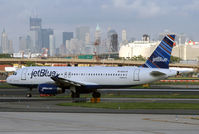N603JB @ KEWR - Viva La Blue taxies out at Newark, with the skyline in the background. - by Daniel L. Berek