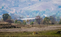 N761DN @ KRNM - The Cessna is landing at KRNM (Ramona, CA) from the west.  This photo provides the illusion that the aircraft must be landing on a dirt strip but the Ramona runway is just beyond the mound. - by ErnieTyler