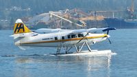 C-FRNO @ CYHC - Harbour Air #301 taxiing to takeoff position in Coal Harbour.  Fibreco wood chip terminal in background in North Vancouver. - by M.L. Jacobs