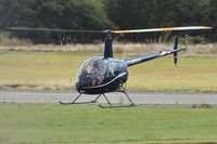 G-MDKD @ EGFH - Recent resident. Heli-air Wales's R-22 helicopter in a new dark blue colour scheme. - by Roger Winser
